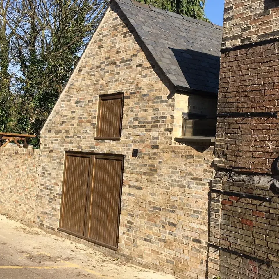 Brick and slate outbuilding with matched stock brickwork and timber doors, by Cambourne Brickwork & Building