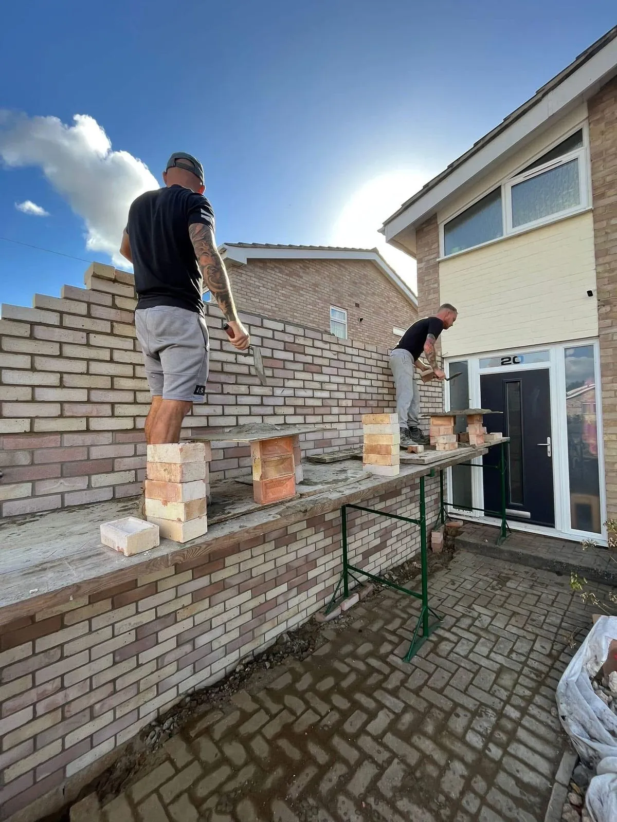Bricklayers building a buff brick garden wall, by Cambourne Brickwork & Building